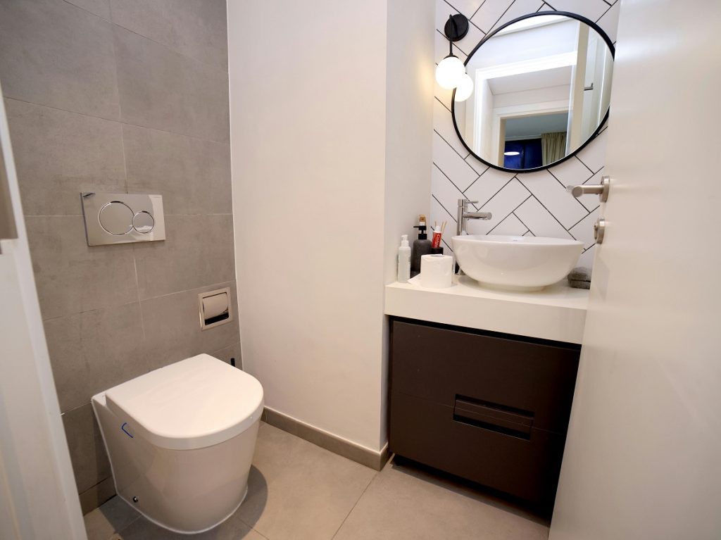 small half bathroom with a tile accent wall behind the vanity