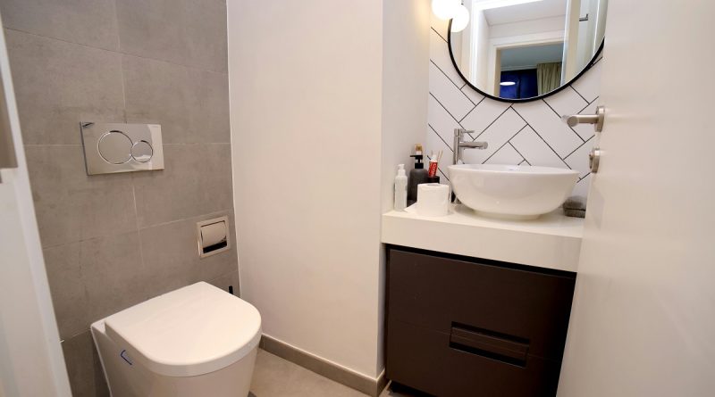 small half bathroom with a tile accent wall behind the vanity
