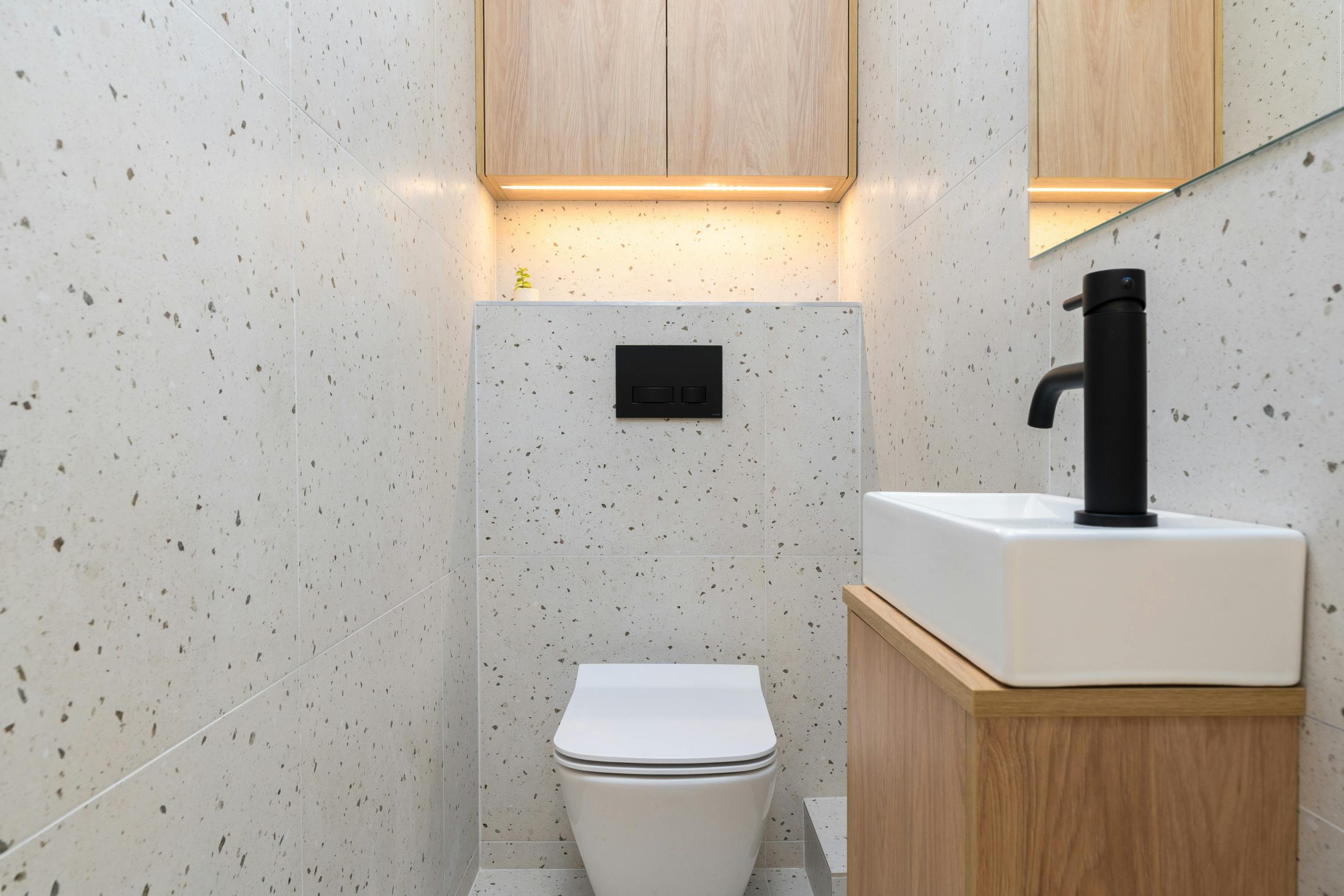 half bathroom with lighted cabinets