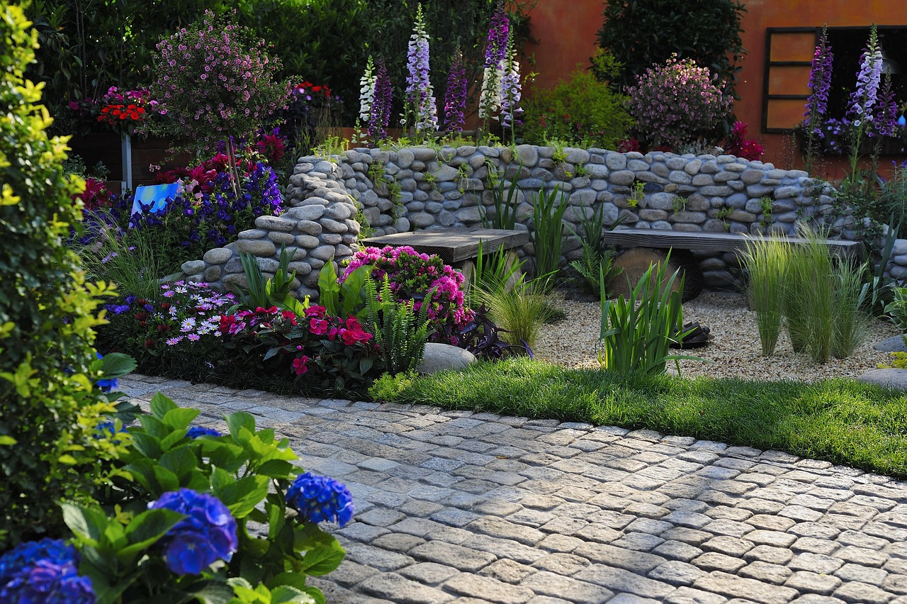 stone front walkway surrounded by shrubs and stone flower beds