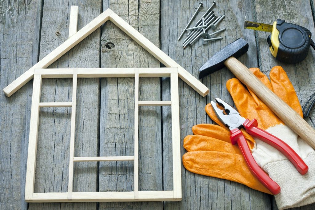 wooden blocks forming a miniature house, with handyman tools scattered nearby