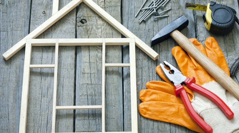 wooden blocks forming a miniature house, with handyman tools scattered nearby